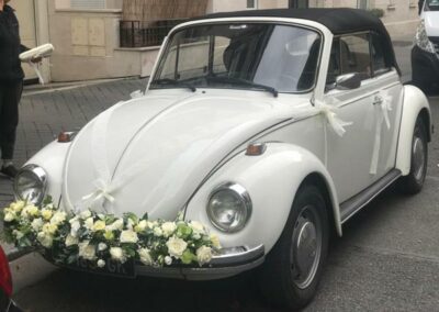 Décoration fleurs blanches sur le devant d'une voiture de mariage