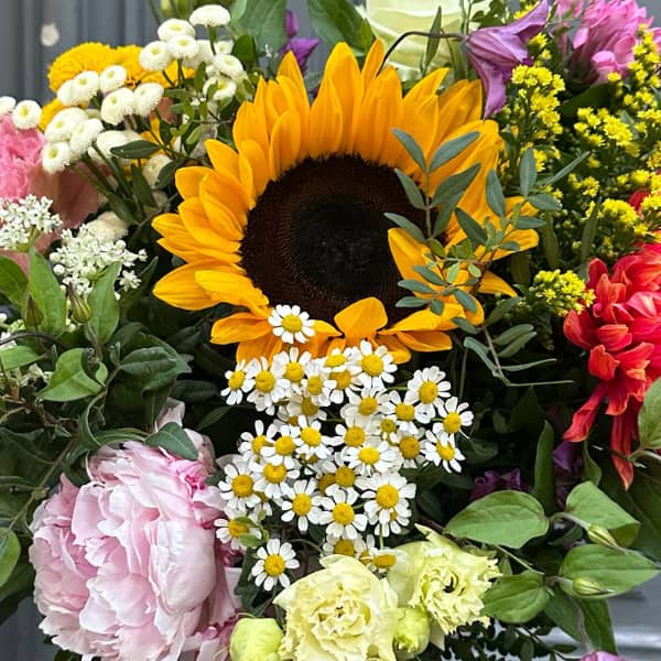 zoom bouquet soleil d'été avec tournesol, pivoine et camomille